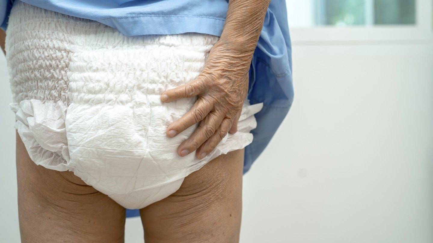 Close-up of breathable continence pads and barrier cream arranged neatly on a bathroom counter
