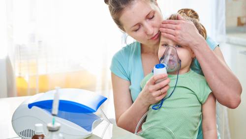 Mother helping child with breathing treatment